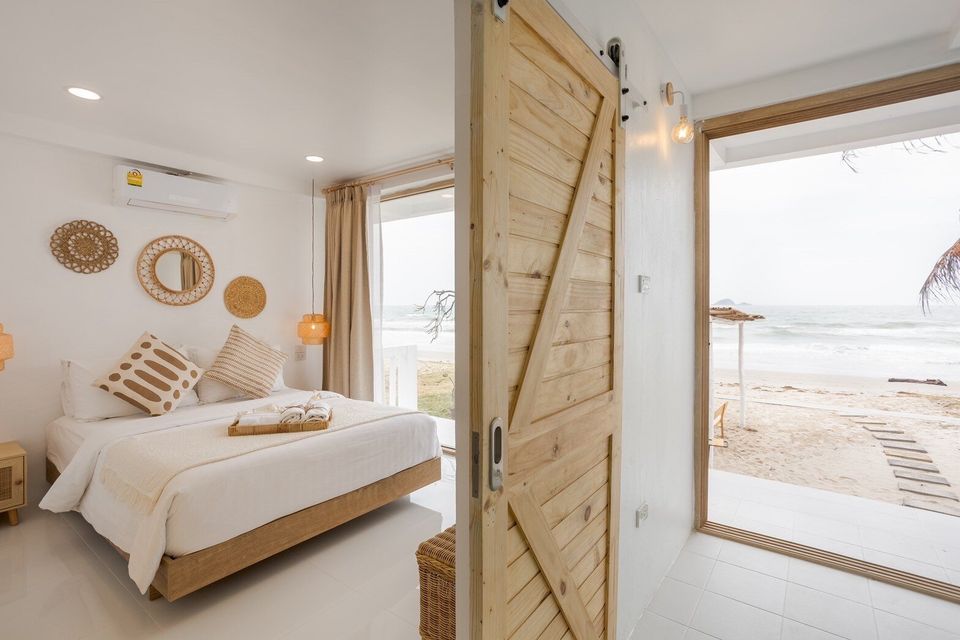Story II Pool Villa Hua-Hin bedroom with a king-size bed, white linens, and direct ocean views from the sliding door.