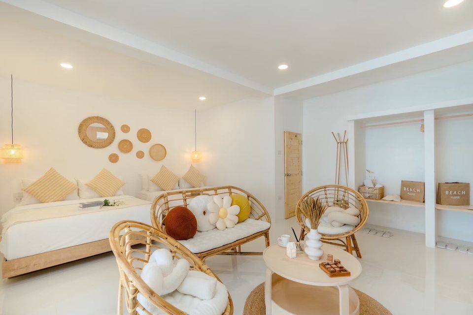 Bright bedroom at Story II Pool Villa Hua-Hin with two queen beds, rattan seating, and woven wall decor. Perfect for familie