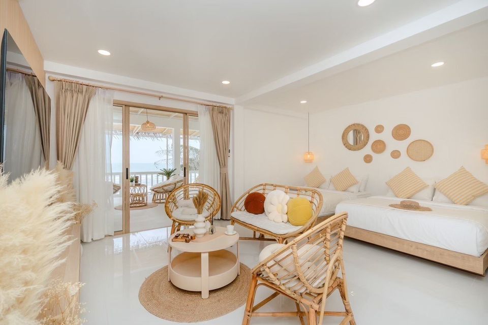 Bright bedroom at Story II Pool Villa Hua-Hin with two beds, rattan furniture, and a balcony overlooking the ocean.