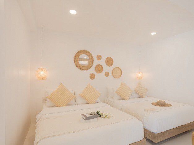 Bright bedroom at Story II Pool Villa Hua-Hin with two comfortable beds, rattan decor, and warm lighting. Perfect for famili