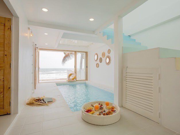 Indoor beachfront pool at Story II Pool Villa Hua-Hin, offering stunning ocean views and a floating breakfast tray.
