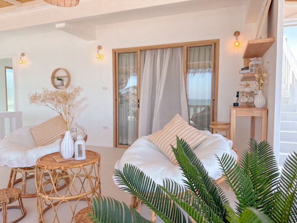 Bright living area with rattan chairs and striped pillows at Story II Pool Villa Hua-Hin, offering a cozy space.