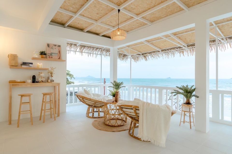 Ocean view terrace at Story II Pool Villa Hua-Hin. Rattan chairs and table on the patio overlooking the sea in Khao Tao.