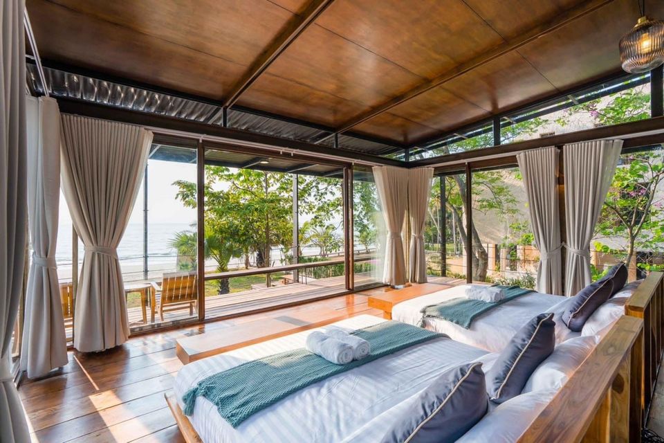 Bright bedroom with two twin beds and direct beachfront views at Studio Beachfront III Pool Villa, Cha-Am.