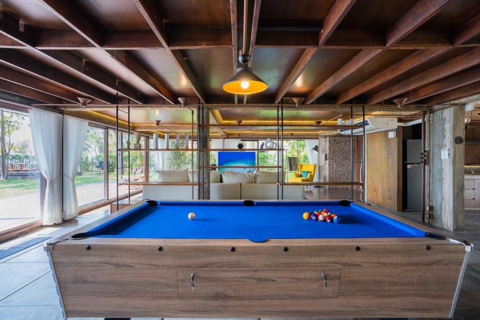 A blue billiards table with cue ball and racked balls in the entertainment room of Studio Beachfront III Pool Villa, Cha-Am.