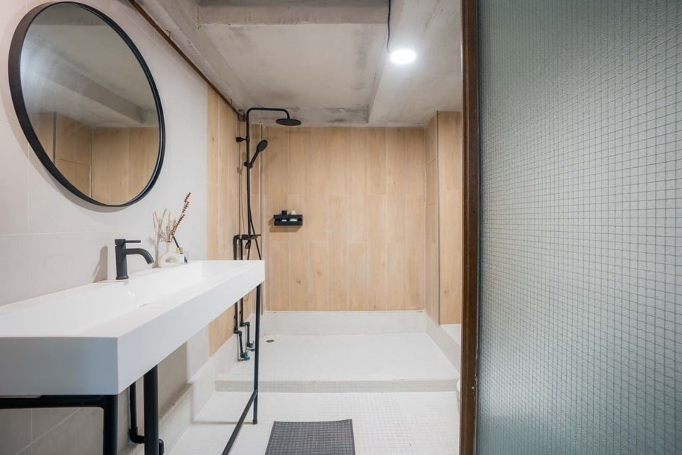 Modern walk-in shower and vanity with round mirror in Studio Beachfront III Pool Villa, Cha-Am. Clean, minimalist design.
