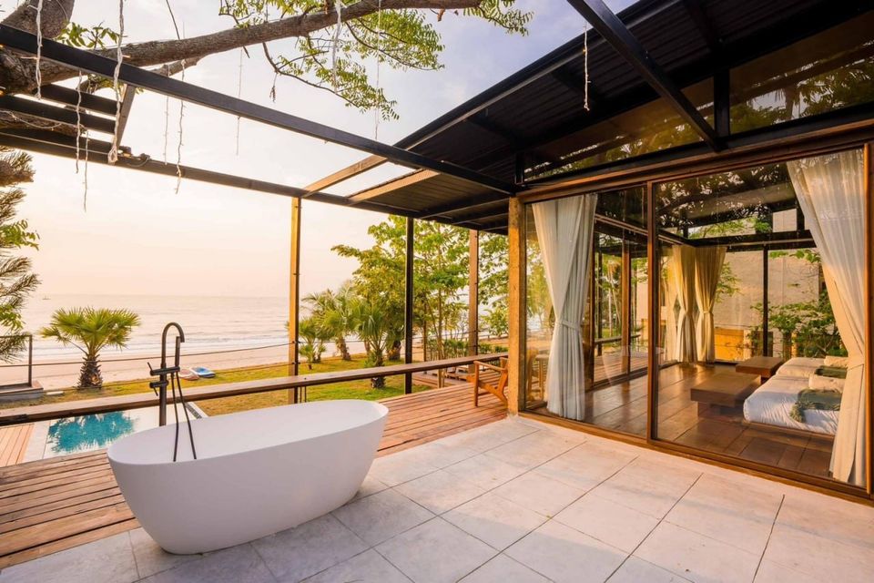 Outdoor bathtub on the terrace of Studio Beachfront III Pool Villa in Cha-Am, overlooking the beach and ocean at sunset.