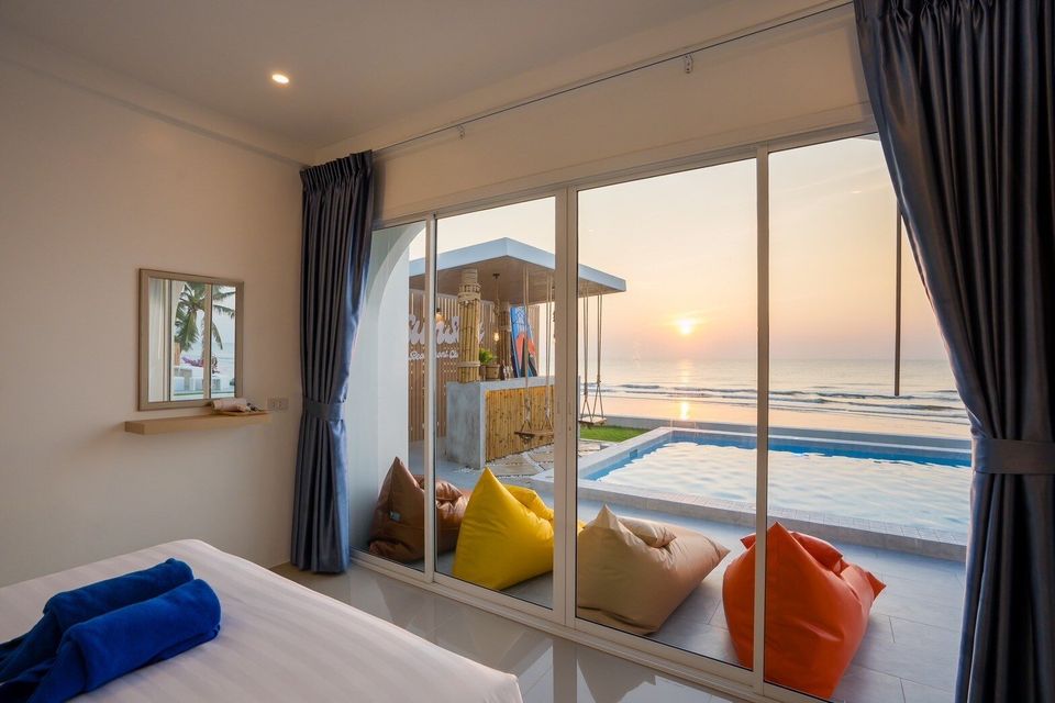 Bedroom window overlooking the pool and ocean at sunset at Sun Sea V Pool Villa