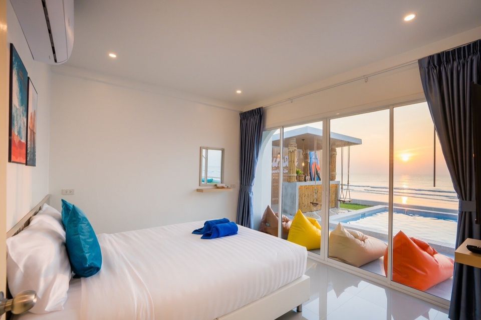 Bedroom with colourful seating and sunset sea view at Sun Sea V Pool Villa