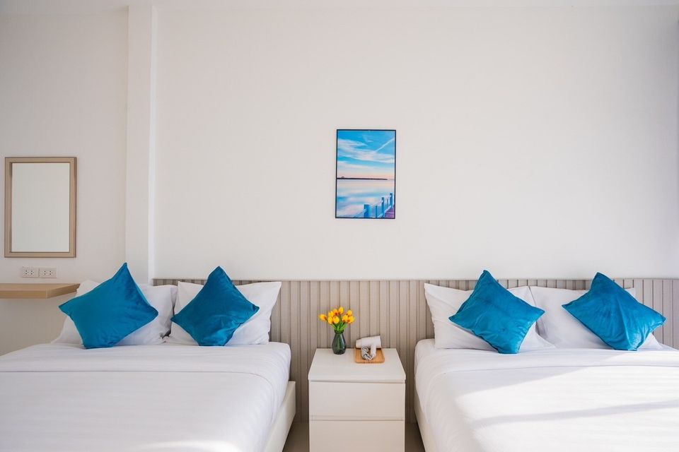 Twin beds with blue pillows at Sun Sea V Pool Villa