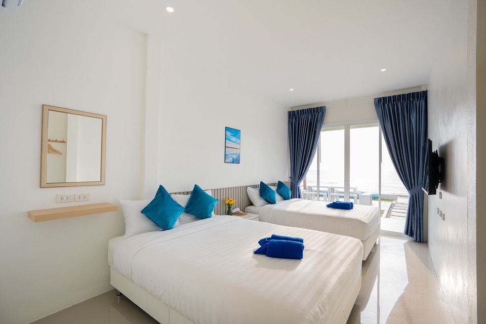 Twin-bed room with mirror and TV at Sun Sea V Pool Villa