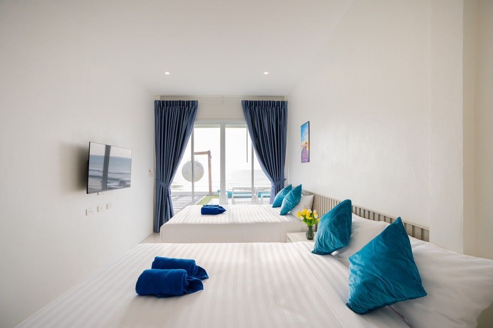 Twin beds facing a large sea-view window at Sun Sea V Pool Villa