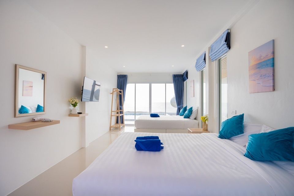 Twin beds, TV, and ocean-view window at Sun Sea V Pool Villa