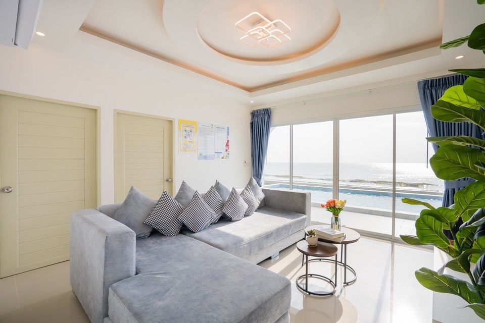Bright sectional sofa beside sea-view windows at Sun Sea V Pool Villa
