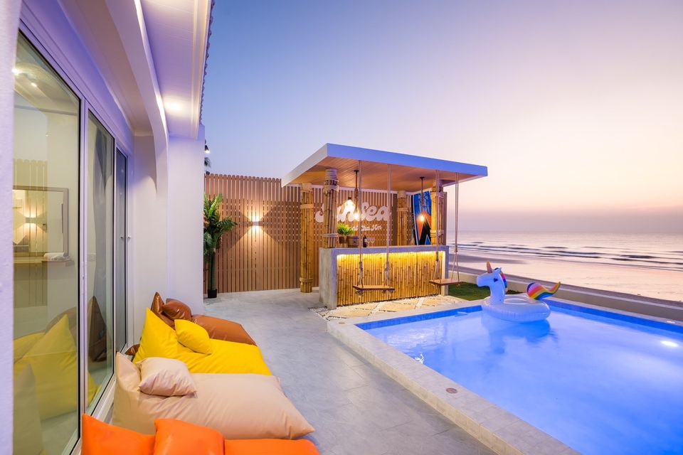 Sun Sea V Pool Villa in Cha Am has a poolside bar and unicorn floatie in the pool at sunset.