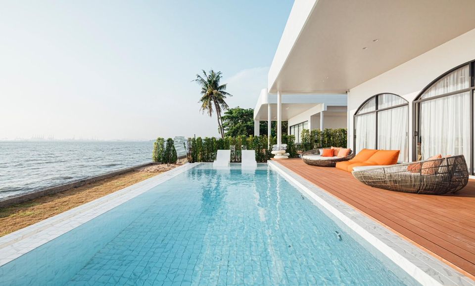 Oceanfront infinity pool and deck at Sun Season V Pool Villa in Banglamung, Pattaya. Loungers and ocean view.