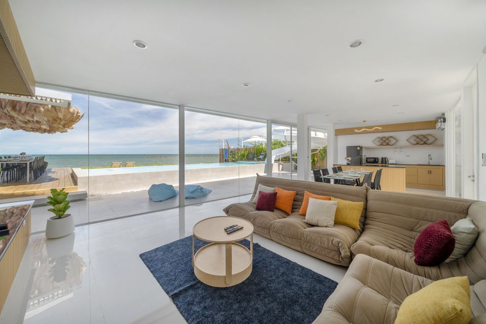 Spacious open-plan living area at Talay Haus X Pool Villa, Cha-Am, with a large sofa, ocean views, and direct pool access.