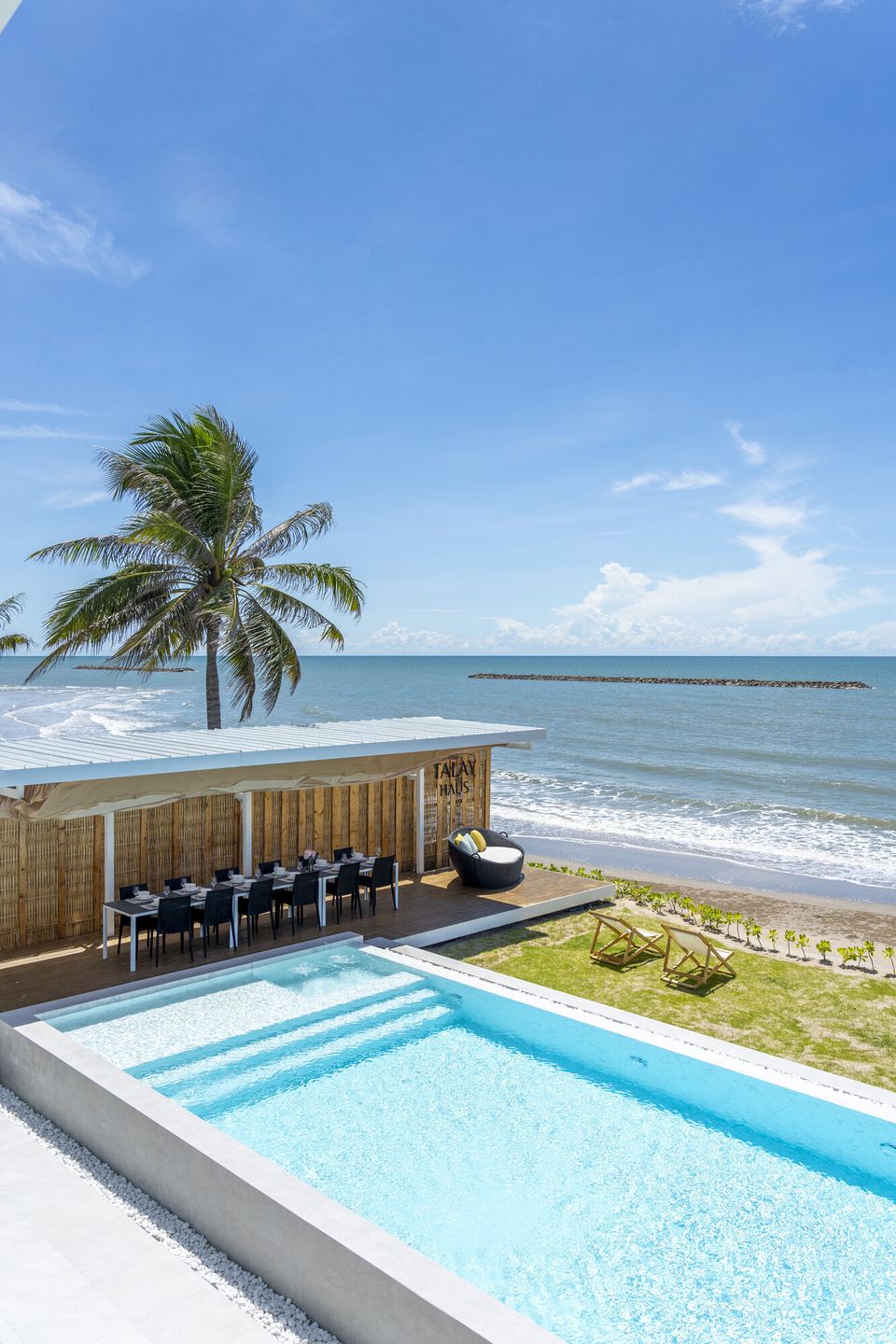 Aerial view of Talay Haus X Pool Villa in Cha-Am, featuring a private pool, beachfront dining area, and ocean views.