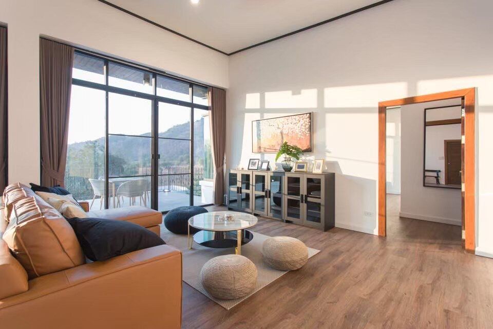 Spacious living room at The Valley Khaoyai V Villa with a comfortable sofa, coffee table, and mountain-view terrace access.