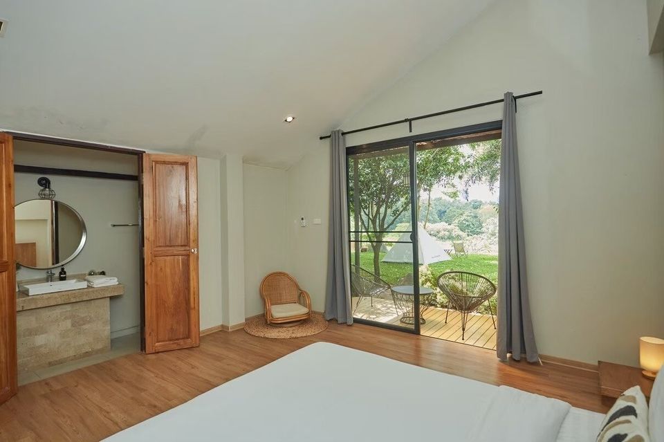 Bedroom at The Valley Khaoyai I with a comfortable bed, private balcony, and lush green views of Khao Yai.