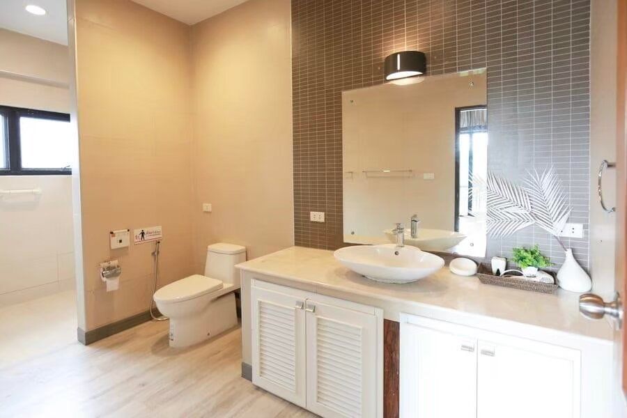 Modern bathroom with white vessel sink, large mirror, and toilet at The Valley Khaoyai I pool villa, Khao Yai.