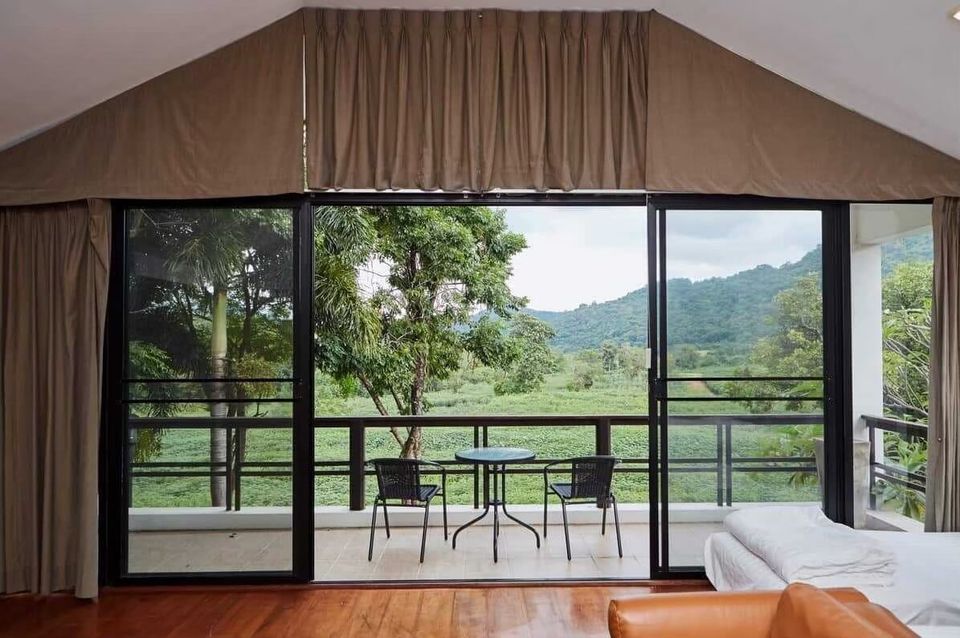 Bedroom at The Valley Khaoyai I with a private balcony, outdoor seating, and stunning mountain views of Khao Yai.