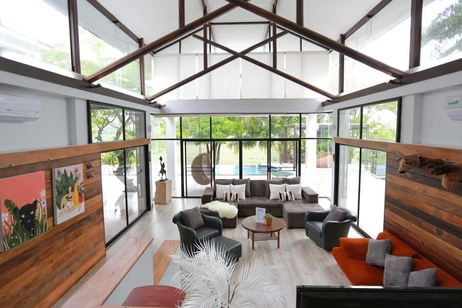 Spacious living room at The Valley Khaoyai I, Khao Yai, featuring high ceilings, comfortable sofas, and large windows...