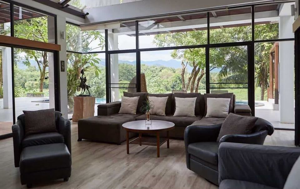 Spacious living room at The Valley Khaoyai I, Khao Yai, featuring a large sofa, armchairs, and stunning mountain views...
