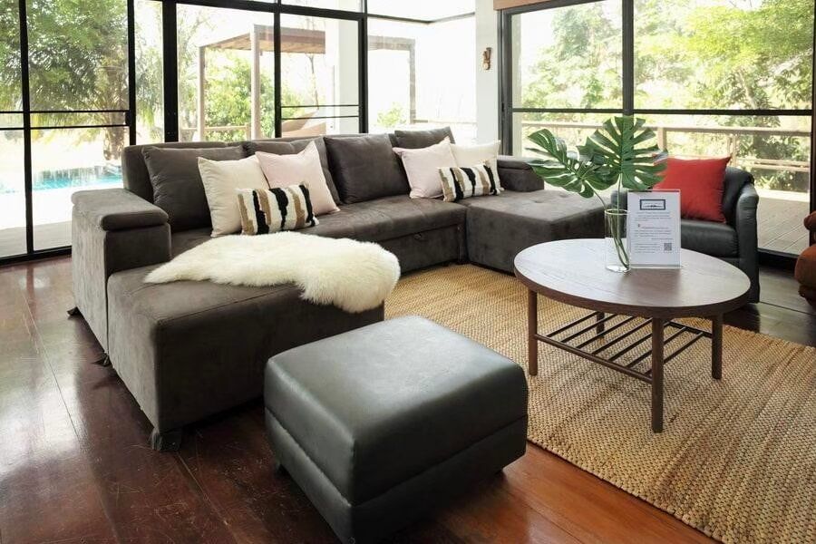 Comfortable L-shaped sofa with plush pillows and a coffee table in the living room of The Valley Khaoyai I pool villa.