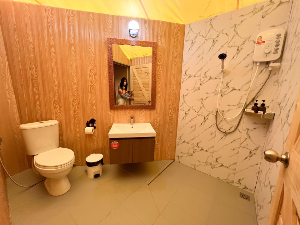 Modern bathroom at The Valley Khaoyai IX Villa with wood-paneled walls, white marble shower, toilet, and vanity.