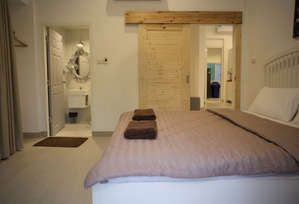 Cozy queen-size bed with pink duvet and brown towels in a bedroom at The Valley Khaoyai IX Villa, Khao Yai.