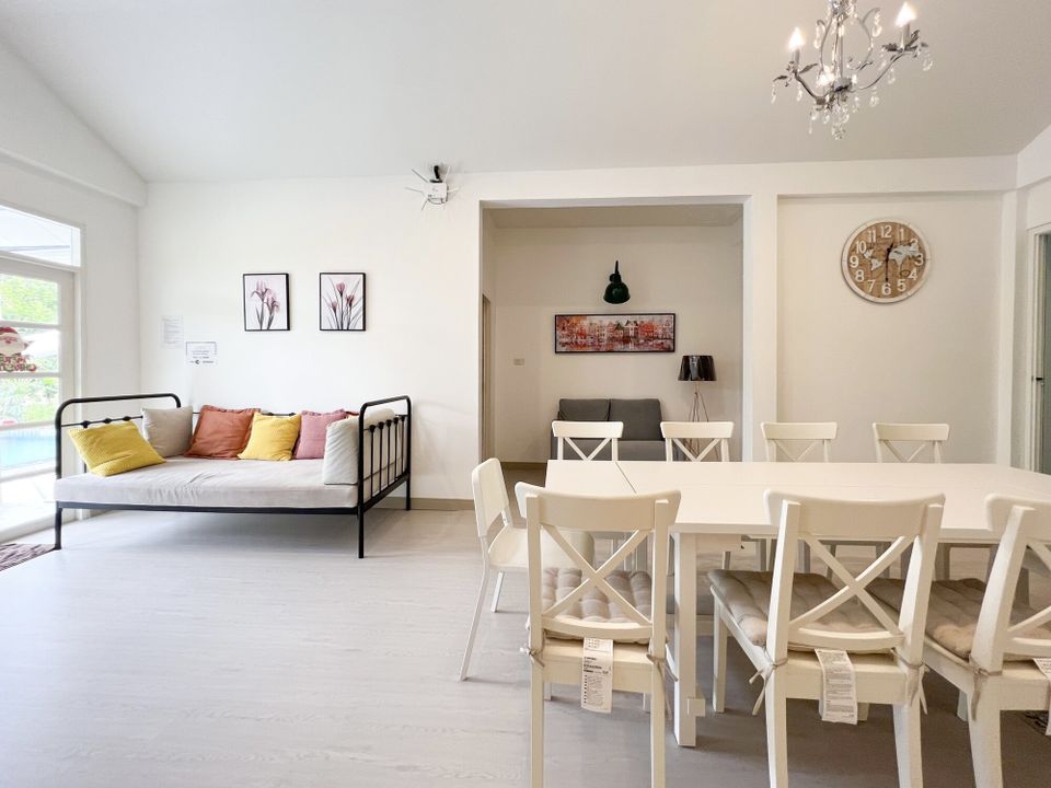 Bright open-plan dining area at The Valley Khaoyai IX Villa, Khao Yai, featuring a large white dining table and chairs.