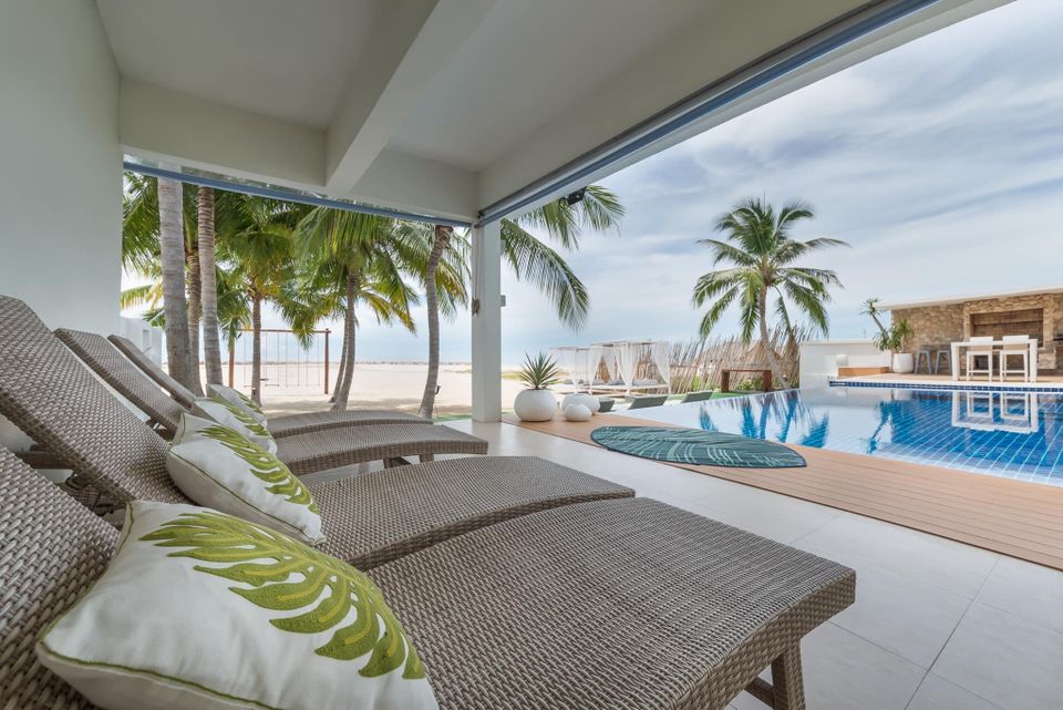 Relax by the pool at Vela VII Pool Villa, Cha-Am. Beachfront loungers and stunning views await your luxury getaway.