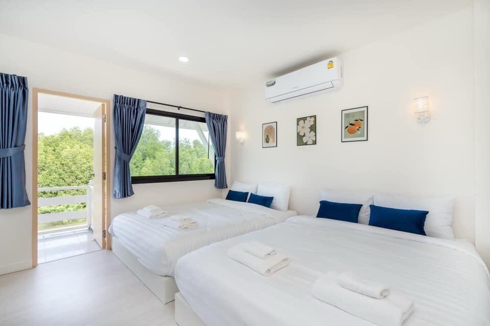 Bright bedroom at View Lay IV Pool Villa, Cha-Am, featuring two comfortable beds, blue accents, and a private balcony.