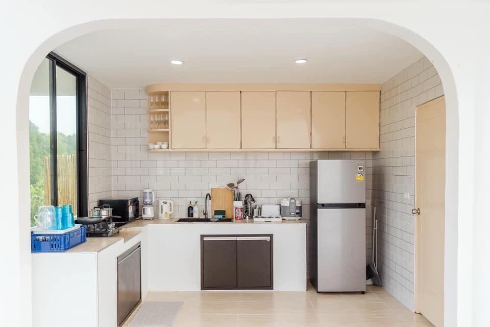 Modern, fully-equipped kitchen at View Lay IV Pool Villa in Cha-Am, featuring a refrigerator, stove, and ample counter space.