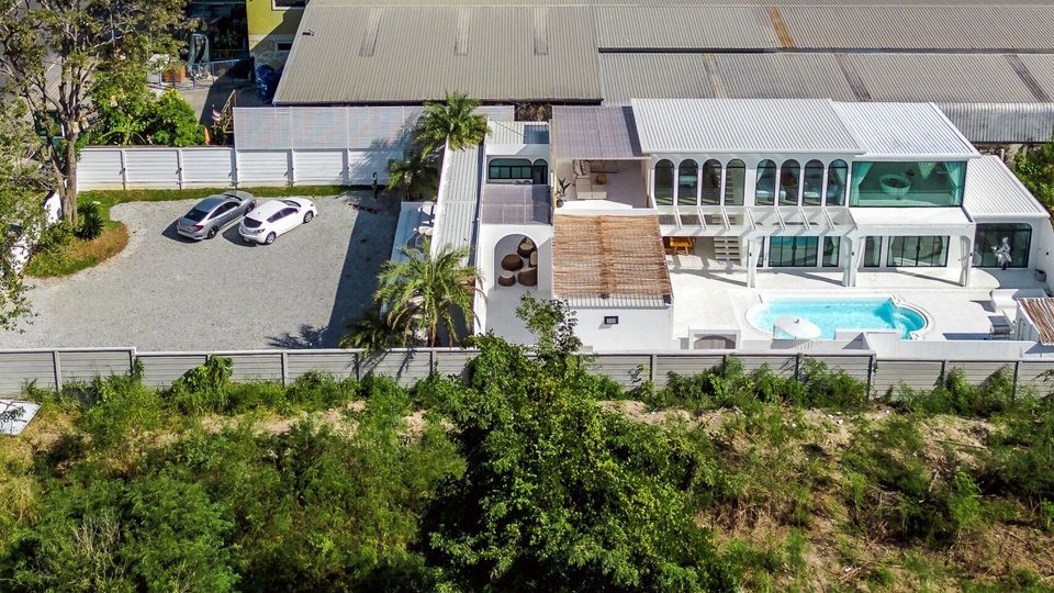 Aerial view of White Coco V Pool Villa, พัทยากลาง-นาเกลือ. Modern white villa with pool, parking, and outdoor spaces.